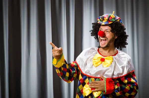 Clown divertente nel concetto umoristico contro tenda — Foto Stock