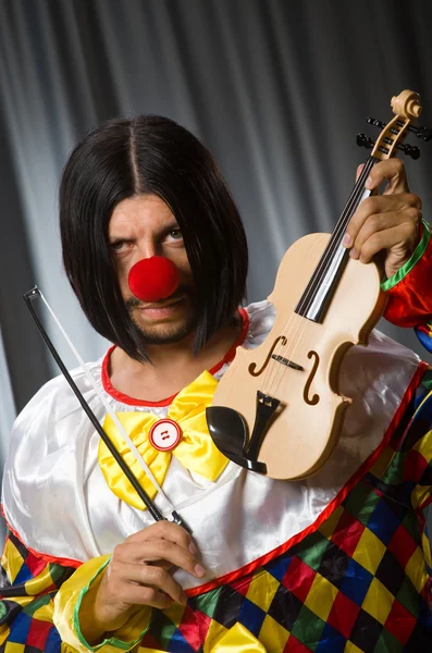 Engraçado palhaço plyaing violino contra cortina — Fotografia de Stock