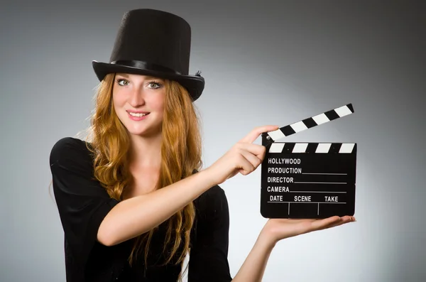 Kvinna med film clapboard mot grå bakgrund — Stockfoto