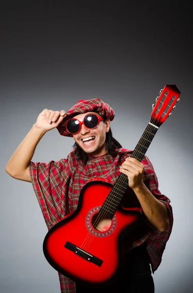 Grappige scotsman spelen Rode gitaar — Stockfoto