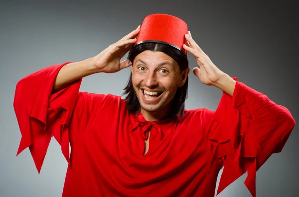 Homem engraçado em vestido vermelho usando fez chapéu — Fotografia de Stock