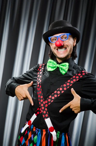 Clown divertente nel concetto umoristico contro tenda — Foto Stock