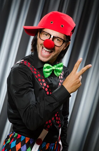 Grappige clown in humoristische concept tegen gordijn — Stockfoto