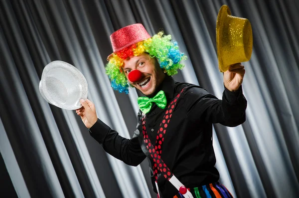 Clown divertente nel concetto umoristico contro tenda — Foto Stock