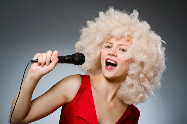 Giovane donna con microfono nel concetto di musica — Foto Stock