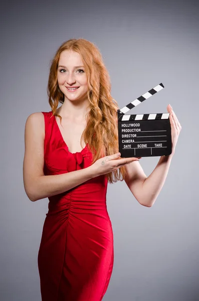 Žena v červených šatech s filmovou deskou — Stock fotografie