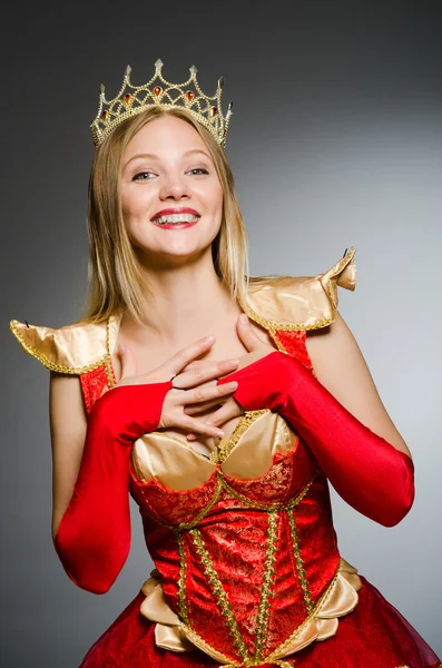 Queen in red costume against dark background — Stock Photo, Image