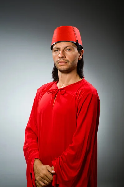 Homem engraçado em vestido vermelho usando fez chapéu — Fotografia de Stock