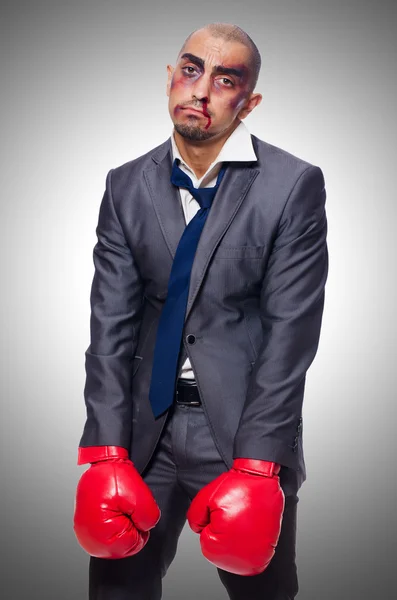 Badly beaten businessman with boxing gloves — Stock Photo, Image