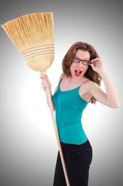 Young woman with broom on white — Stock Photo, Image