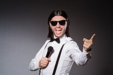 Konserde mikrofonlu komik bir şarkıcı.