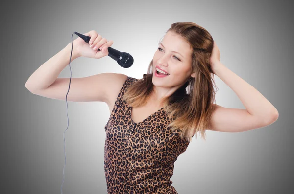 Woman singer with microphone on white — Stock Photo, Image