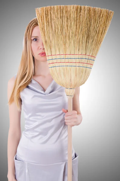 Young woman with broom on white — Stock Photo, Image