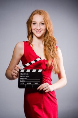 Film tahtası olan kırmızı elbiseli bir kadın.