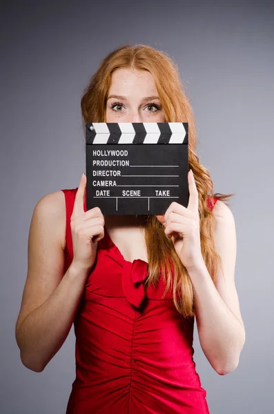 Vrouw in rode jurk met filmbord — Stockfoto