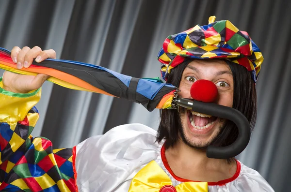 Lustiger Clown mit buntem Regenschirm — Stockfoto