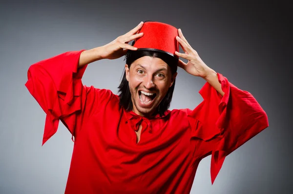 Homem engraçado em vestido vermelho usando fez chapéu — Fotografia de Stock