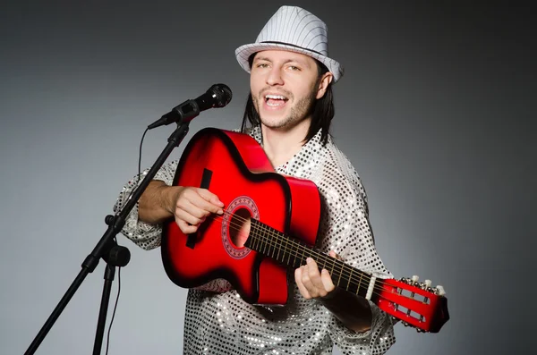 Uomo con chitarra che canta con microfono — Foto Stock