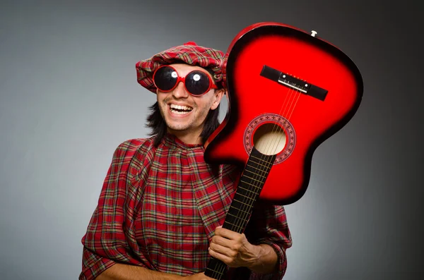 Funny scotsman playing red guitar — Stock Photo, Image