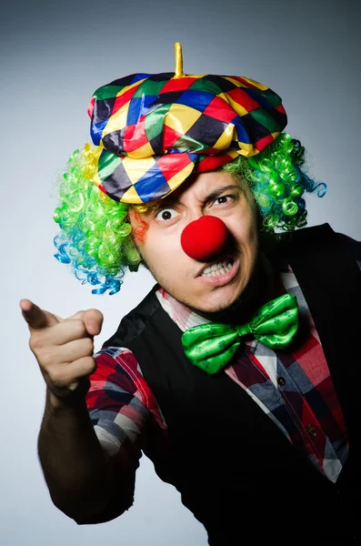 Grappige clown tegen de donkere achtergrond — Stockfoto