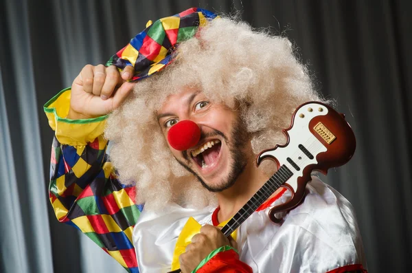 Arg clown med gitarr i roligt koncept — Stockfoto