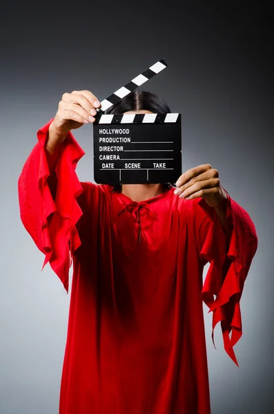 Man in red dress with movie clapboard — Stock Photo, Image