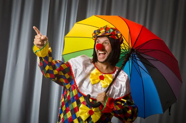 Grappige clown met kleurrijke paraplu — Stockfoto