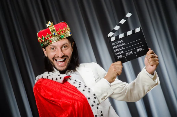 König mit Filmtafel in lustigem Konzept — Stockfoto