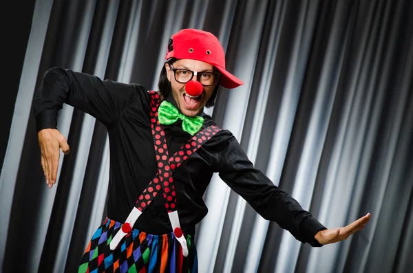 Grappige clown in humoristische concept tegen gordijn — Stockfoto