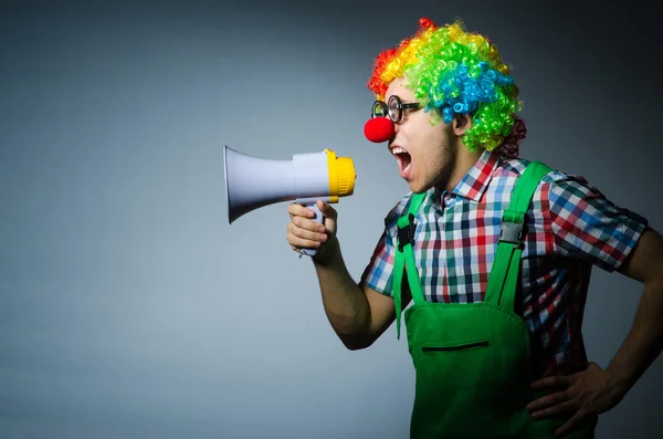 Clown with loudspealer against curtain — Stock Photo, Image