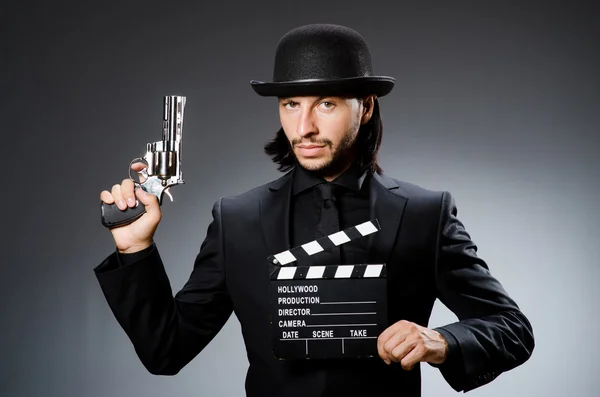 Man with gun and movie clapboard — Stock Photo, Image