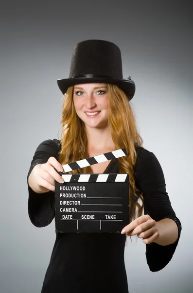 Frau mit Filmklappbrett vor grauem Hintergrund — Stockfoto