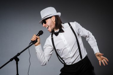 Konserde mikrofonlu komik bir şarkıcı.