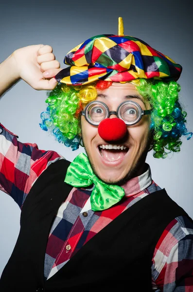 Grappige clown tegen de donkere achtergrond — Stockfoto