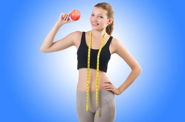 Woman with apple doing exercises — Stock Photo, Image