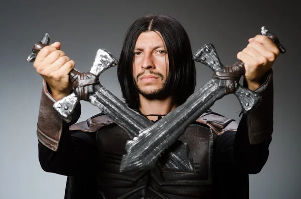 Angry knight with sword against dark background — Stock Photo, Image