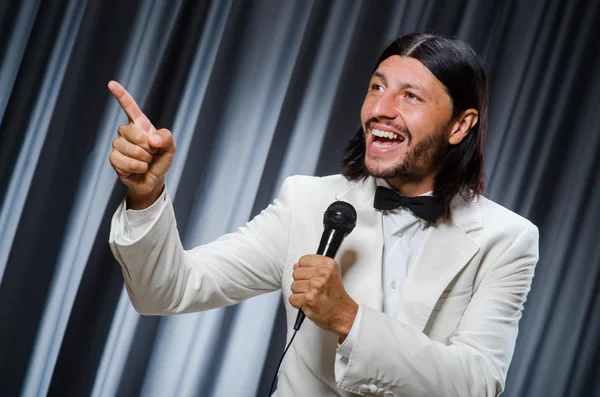 Homem cantando na frente da cortina no conceito de karaoke — Fotografia de Stock