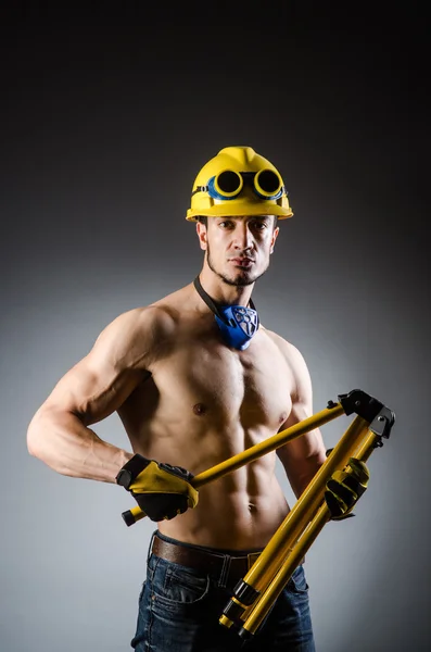 Разорванный мускулистый строитель с инструментами — стоковое фото