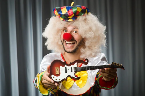 Arg clown med gitarr i roligt koncept — Stockfoto