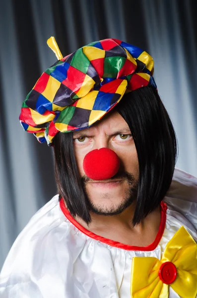 Trieste clown tegen de grijze achtergrond — Stockfoto
