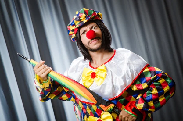 Grappige clown met kleurrijke paraplu — Stockfoto