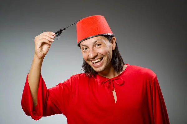 Homem engraçado em vestido vermelho usando fez chapéu — Fotografia de Stock