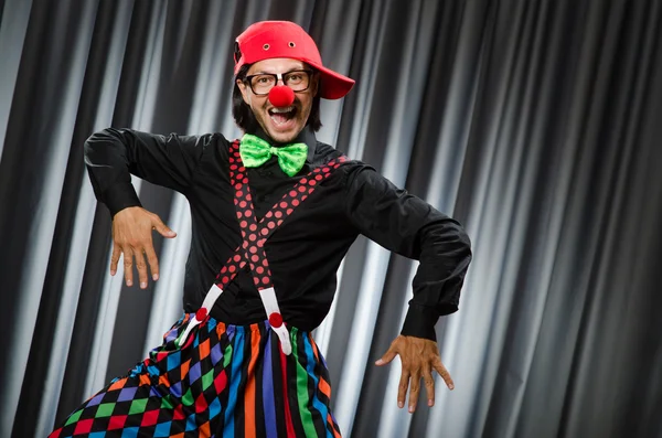 Смішний клоун в гумористичній концепції проти штор — стокове фото