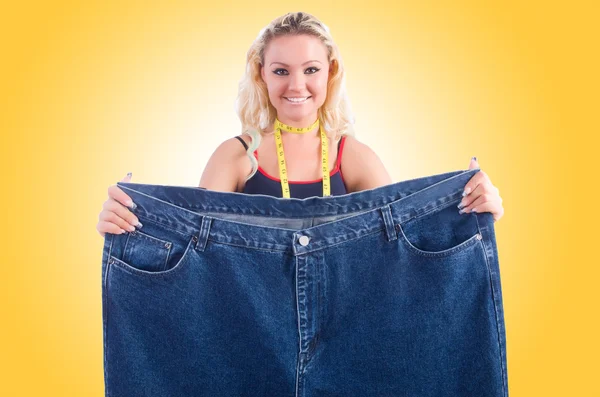 Woman in dieting concept with big jeans — Stock Photo, Image