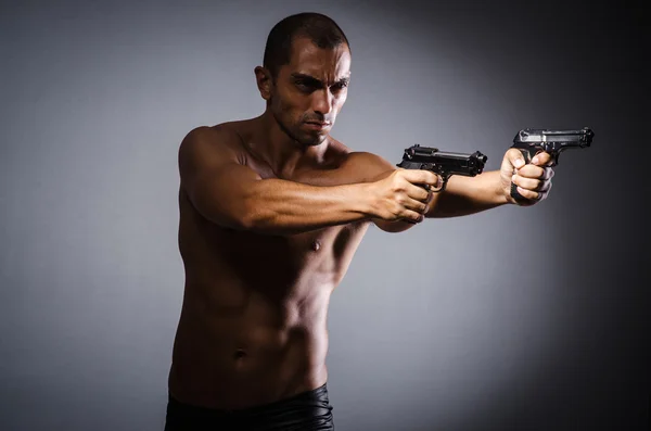 Hombre desgarrado con arma contra fondo gris —  Fotos de Stock