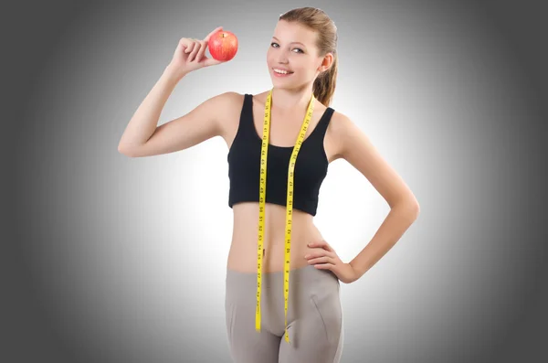 Woman with apple doing exercises — Stock Photo, Image