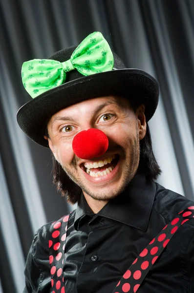 Lustiger Clown mit humorvollem Konzept gegen Vorhang — Stockfoto