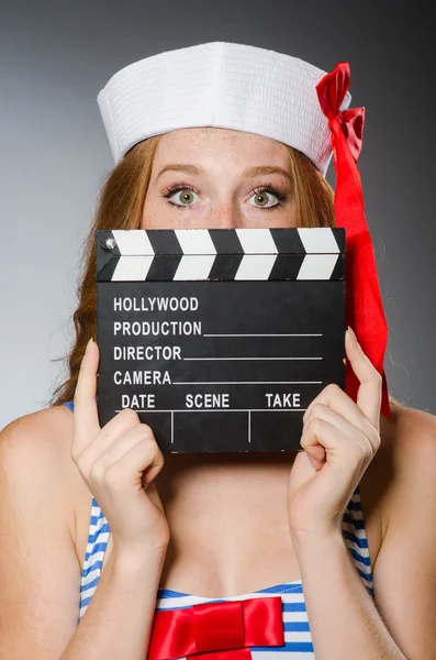 Young woman sailor with movie board