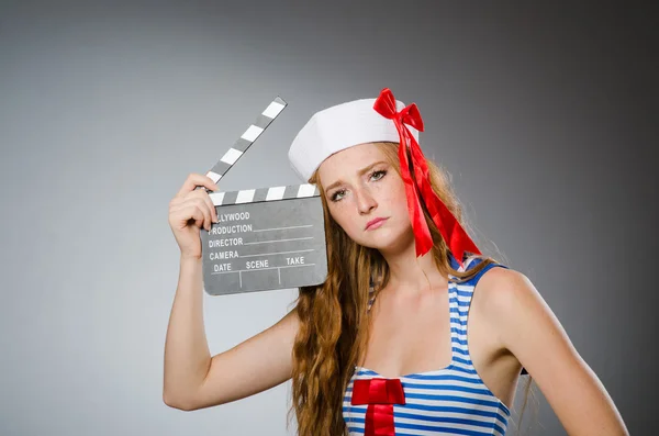 Молодая женщина моряк с кино доска — стоковое фото