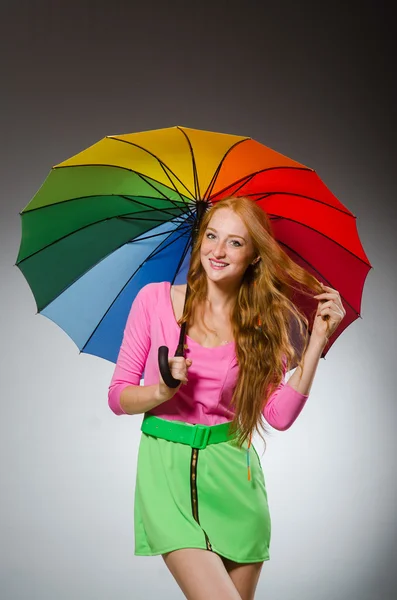 Donna che tiene un ombrello colorato in studio — Foto Stock